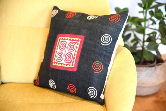 Black hemp cushion with pink spiral styled with plant decor