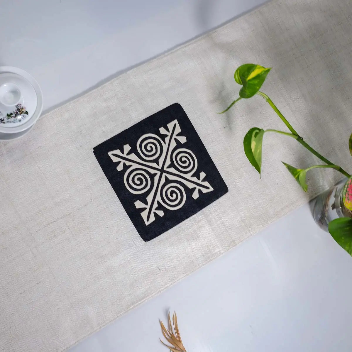 Vindigo beige hemp table runner center view with black cotton embroidered motif