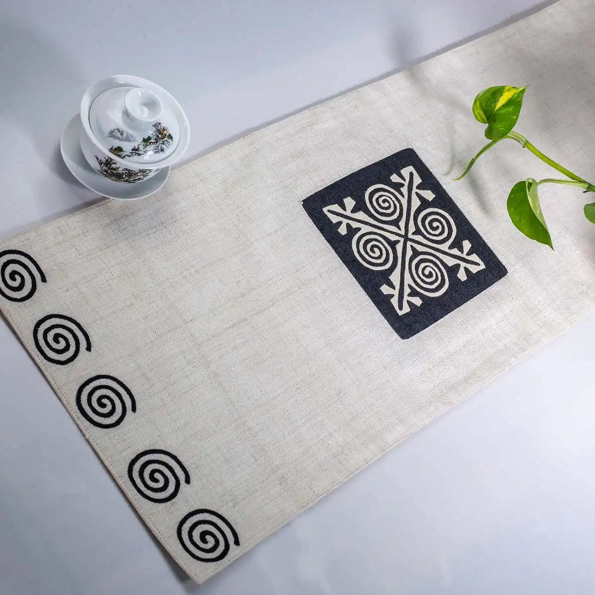 Vindigo beige hemp table runner angled view showing spiral end and center embroidery