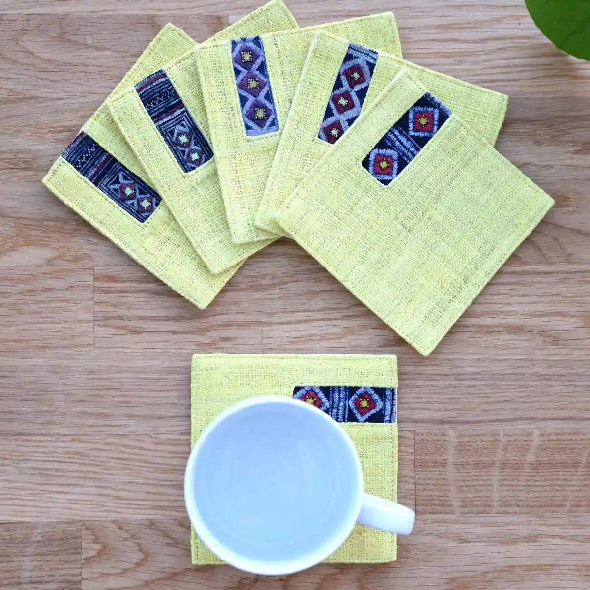 Yellow hemp coaster set with indigo detail styled with cup
