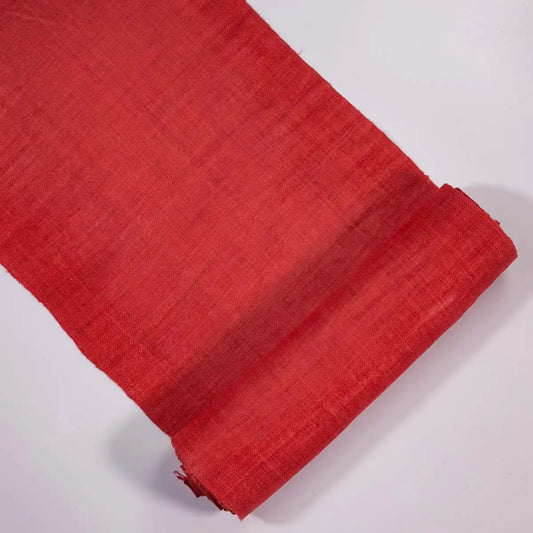 Vindigo red hemp fabric roll partially unrolled on white background