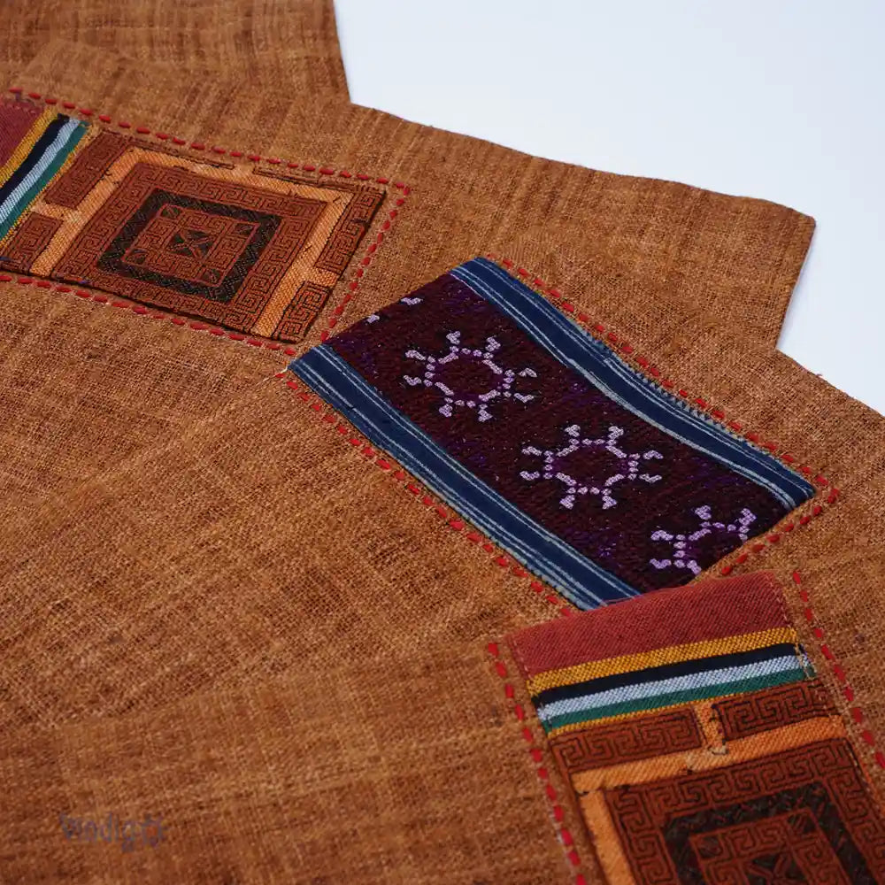 Närbild av handsydda tribalrutor i blått och brunt på linneunderlägg