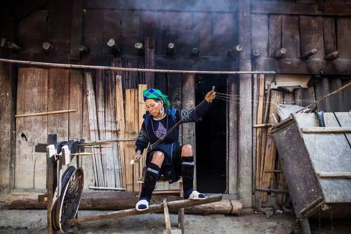 Hmong artisan weaving cloth by hand at wooden loom