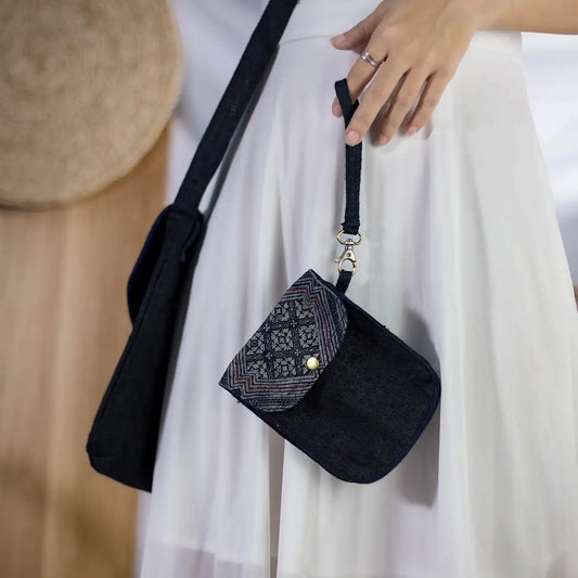 Model carrying black hemp flip phone belt bag with H’Mong patch, eco-friendly handmade accessory.