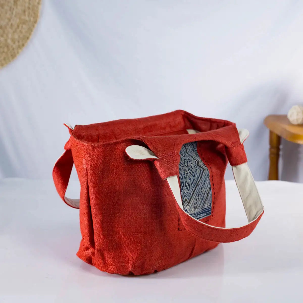 Top view of red hemp bunny ear handbag with open design and vintage H’Mong fabric patch