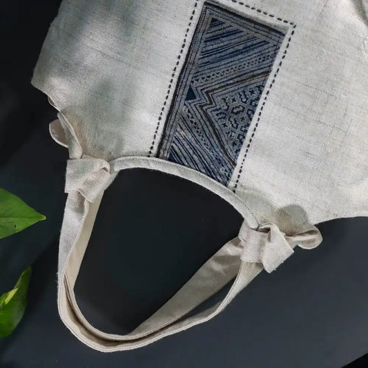 Natural hemp handbag with bamboo handle, side view showing batik patch design