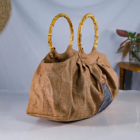 Angled view of natural hemp brownbucket bag with bamboo handles & H’Mong patch