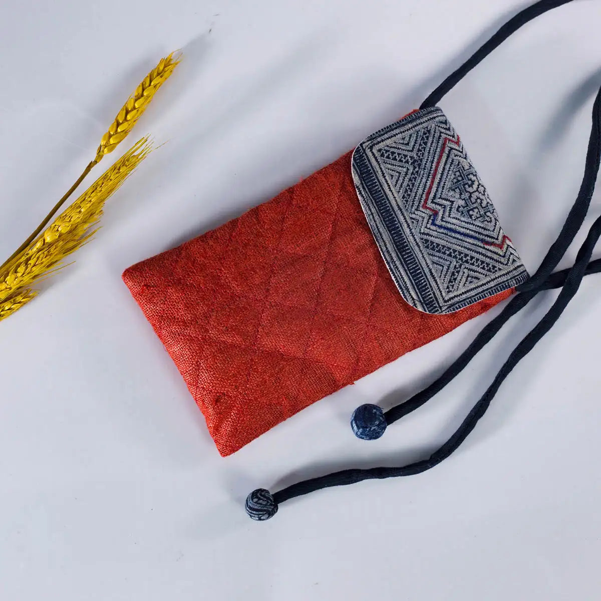 Open view of red hemp mobilväska phone bag with strap, showing H’mong patch detail