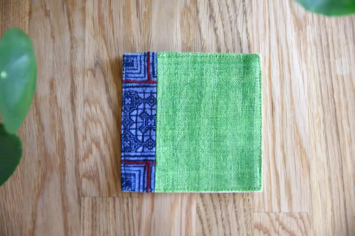 Flatlay of green hemp coaster with indigo woven border on wood surface