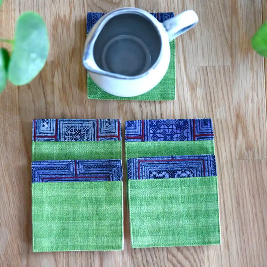 Green hemp coaster with indigo trim styled with teapot on wooden table
