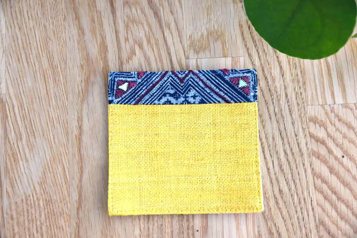 Front view of yellow hemp coaster with indigo fabric trim