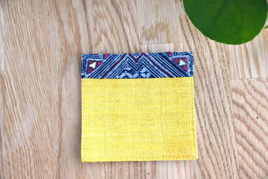 Front view of yellow hemp coaster with indigo fabric trim