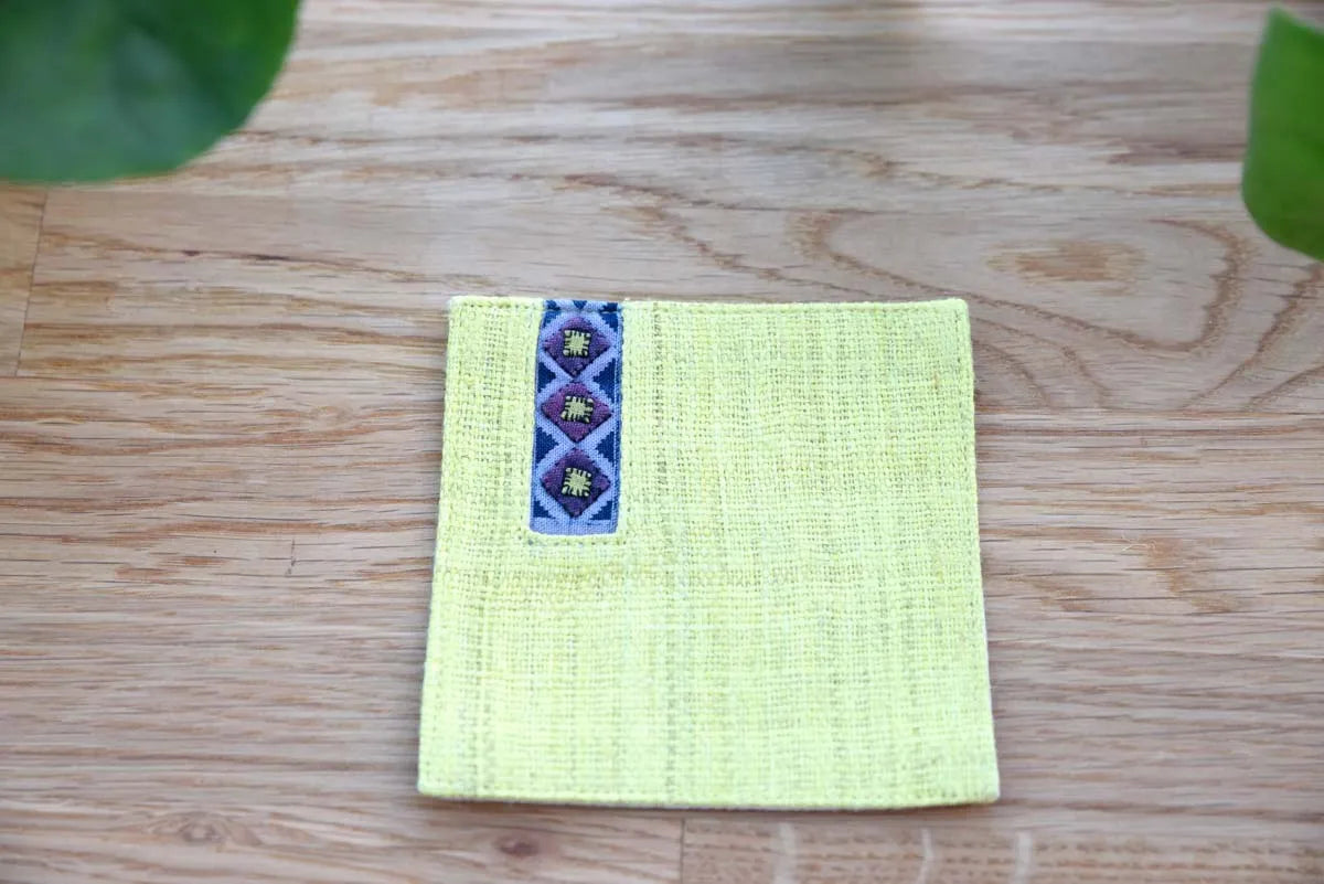 Close-up of indigo handwoven trim on yellow hemp coaster