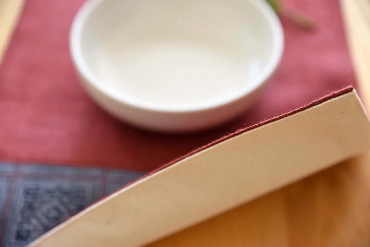 Edge view of handmade hemp placemat in burgundy red tone