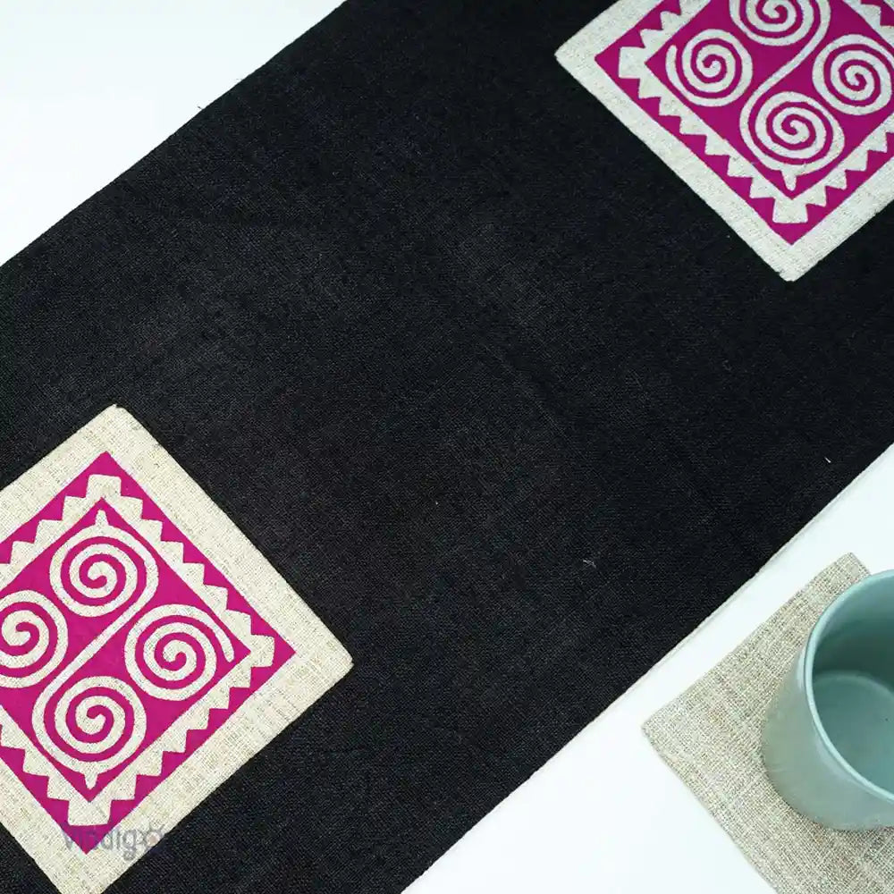 Närbild av rosa tribalruta på svart linnelöpare med kopp bredvid