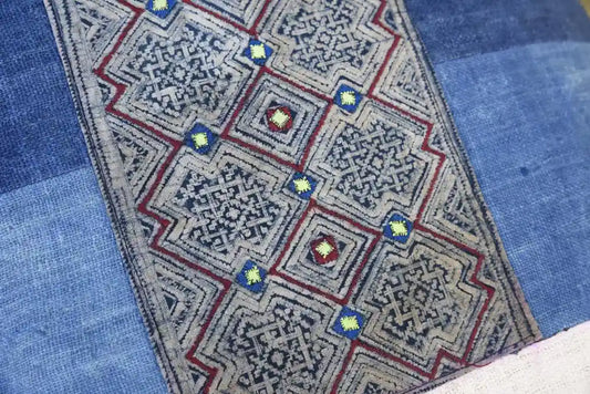 Närbild av geometriskt broderi i tribaltyg med blå detaljer