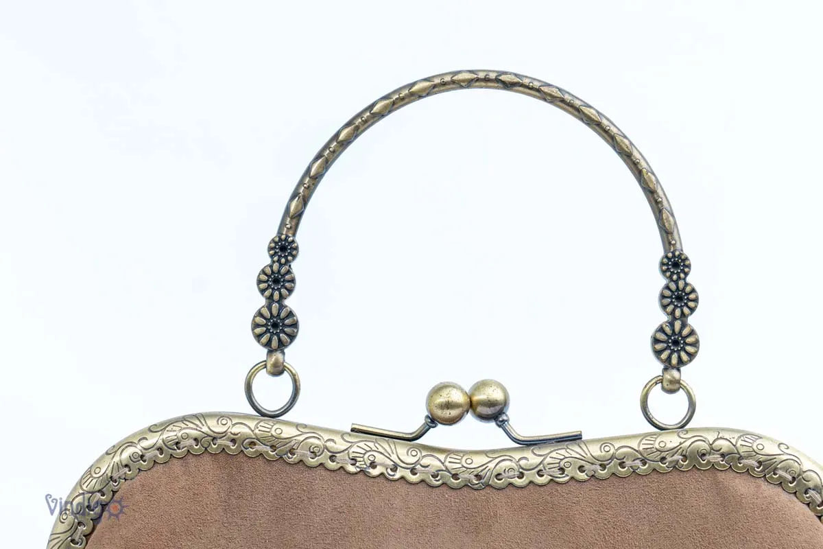 Vindigo handbag showing copper handle with rhombus carving details