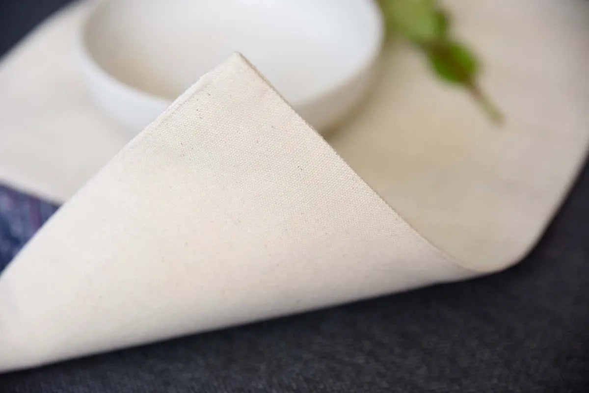 Folded corner of handmade hemp placemat in natural cream tone
