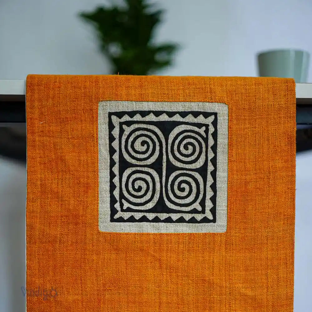 Orange hampalöpare med svart geometriskt tribaltryck på kortsidan