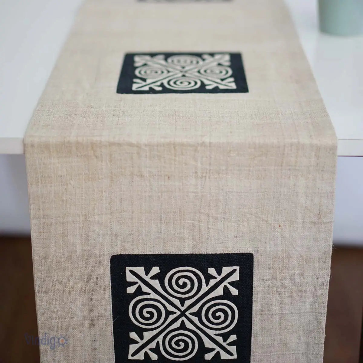 Linnelöpare med svart tribalruta placerad mitt på bordet