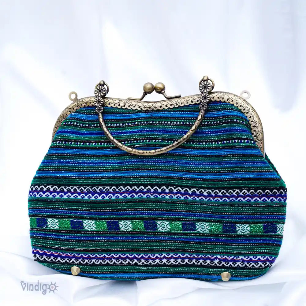 Blå handväska i tribaltyg med klassiskt metallspänne och hantverkssöm