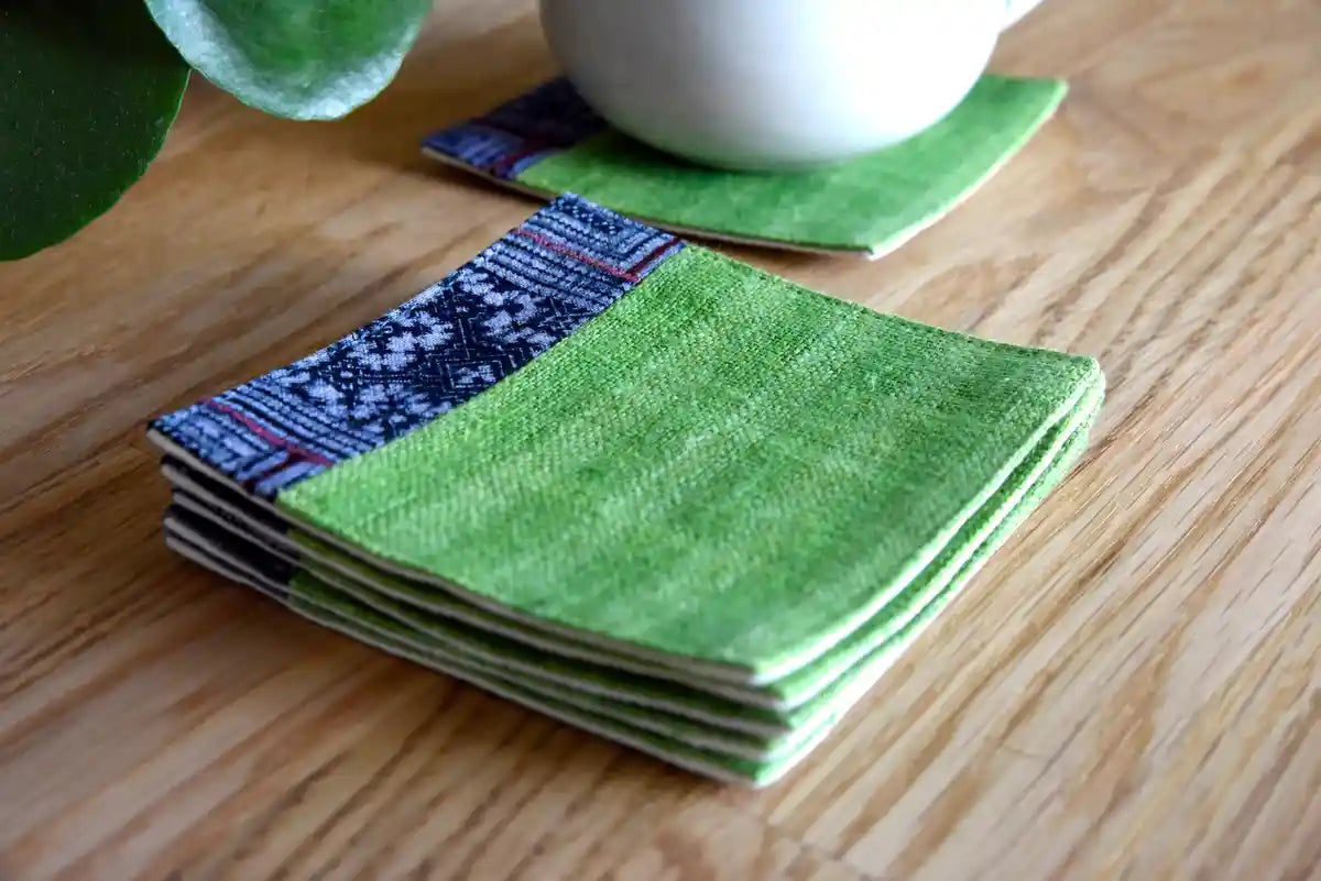 Stacked green hemp coasters with blue indigo accent trim