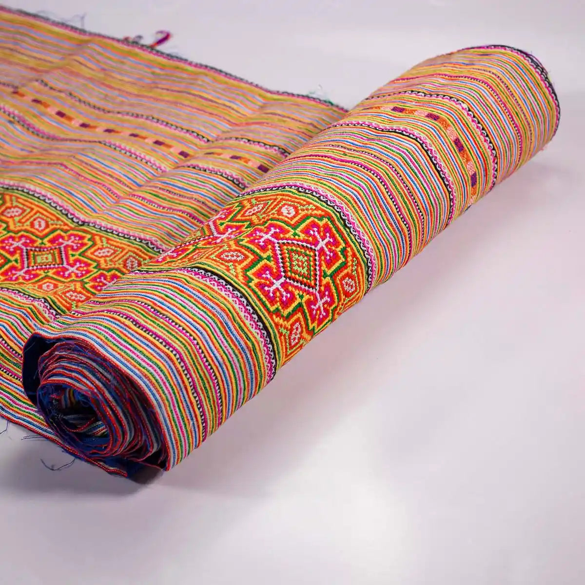Vindigo handmade orange cotton fabric roll showing embroidery edge