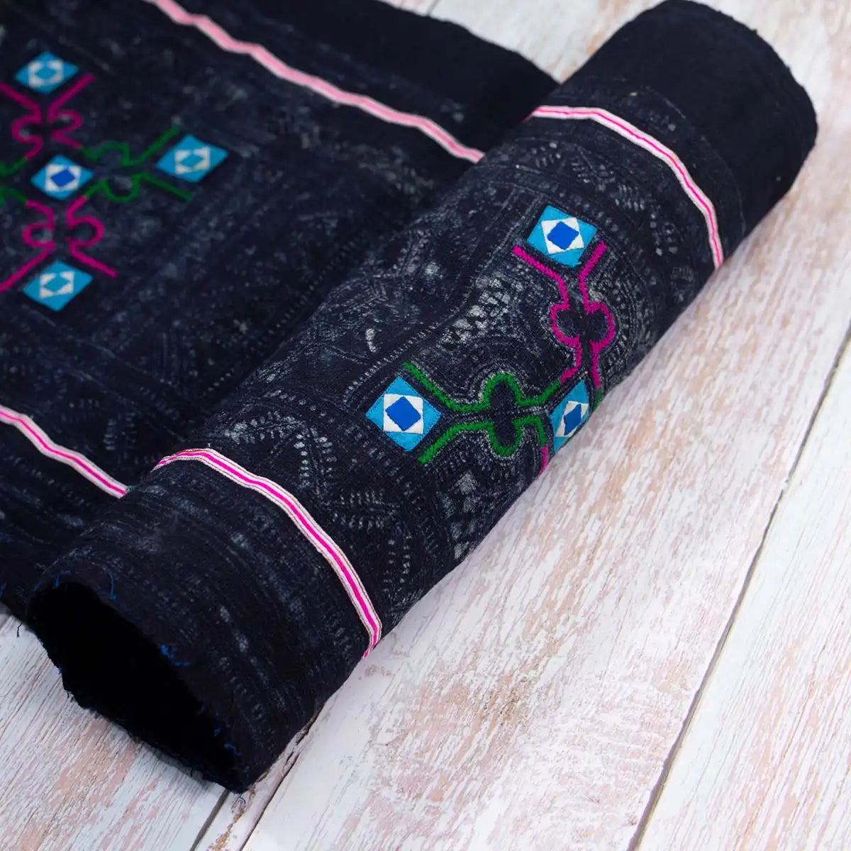 Vindigo embroidered black Hmong fabric, rolled with soft pink stripe