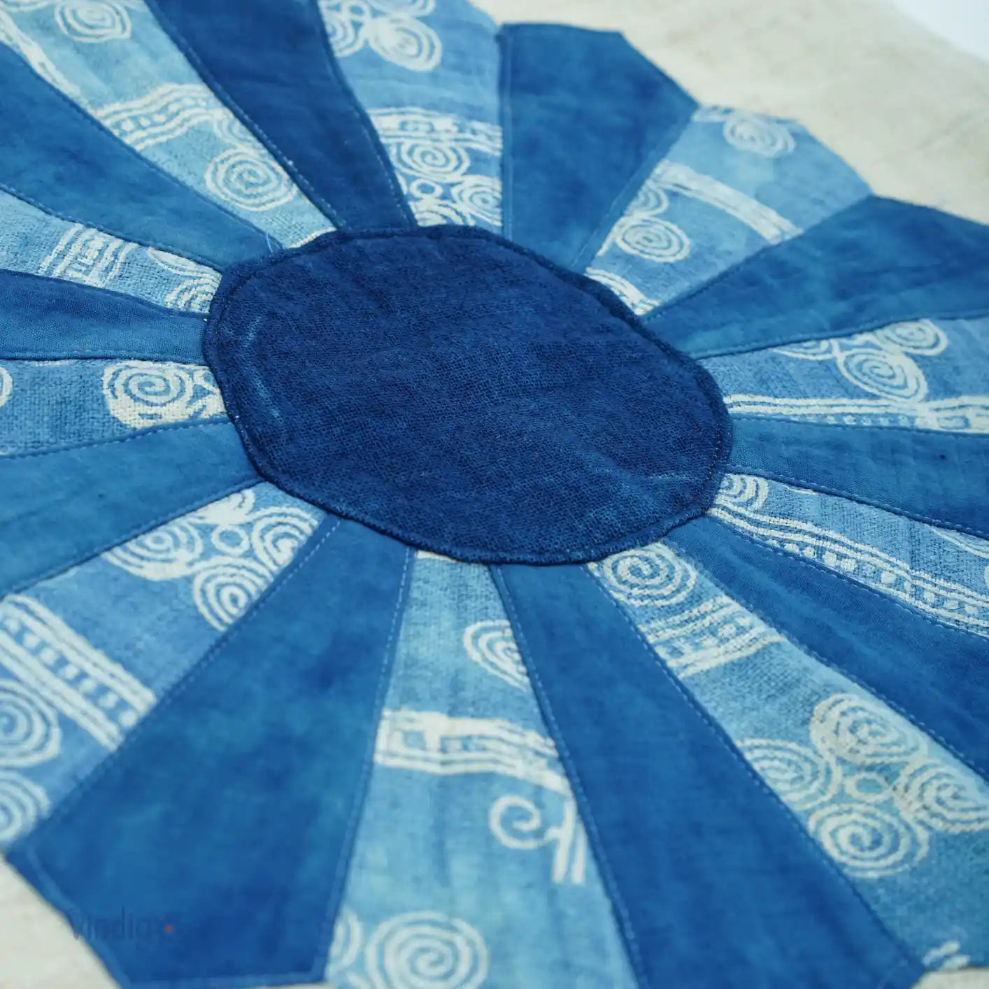 Närbild av kuddfodralets blå batikblomma med kontrasterande nyanser