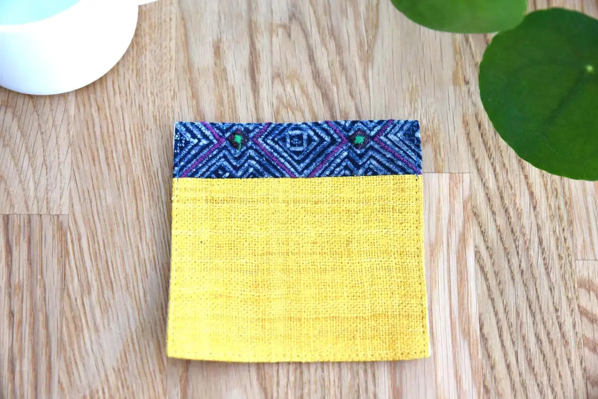 Fabric texture close-up of yellow hemp coaster with blue accent