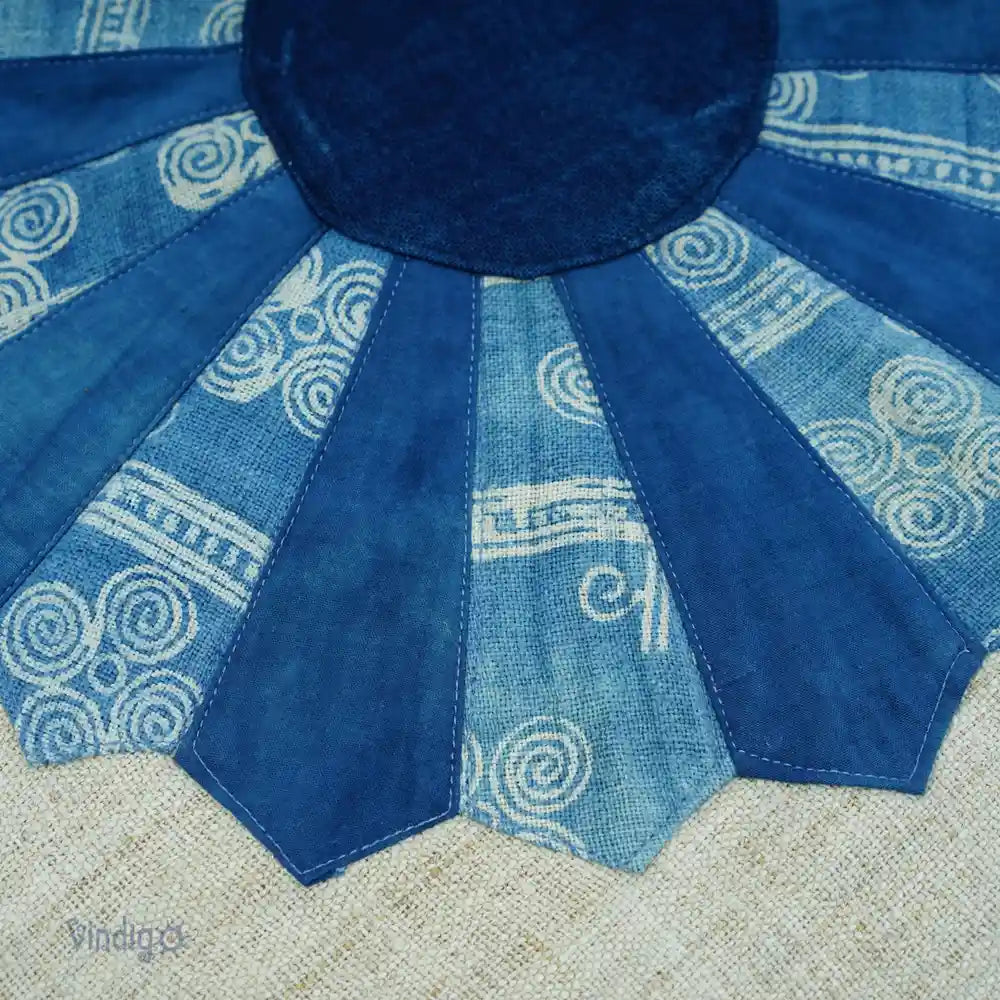 Texturdetalj av blå batikblomma i handsydd patchworkdesign