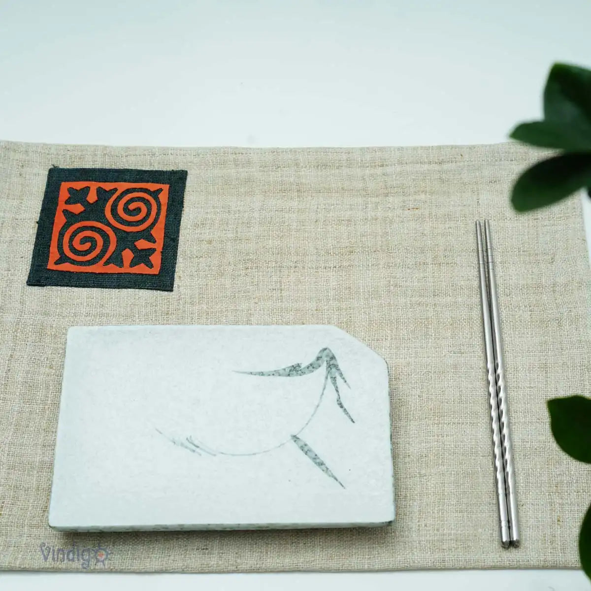 Linneservett med orange tribaltryck dukad på bord i ljus miljö