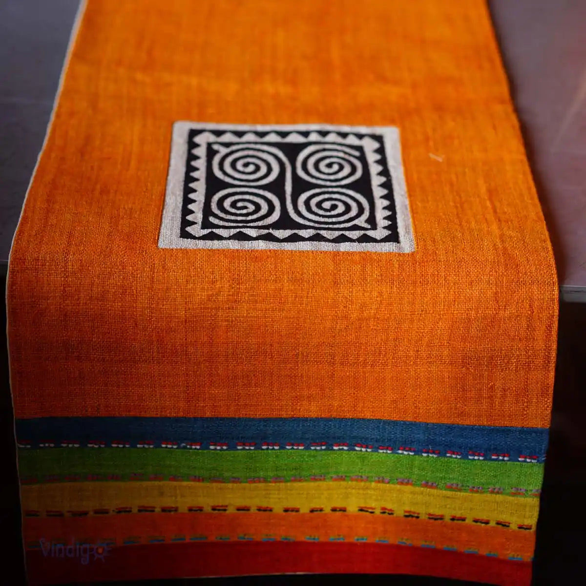 Detalj av orange hampalöpare med tribaltryck och vävda färgkanter