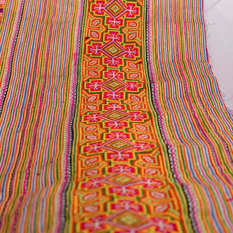 Vindigo orange cotton tribal embroidered fabric flat laid front view