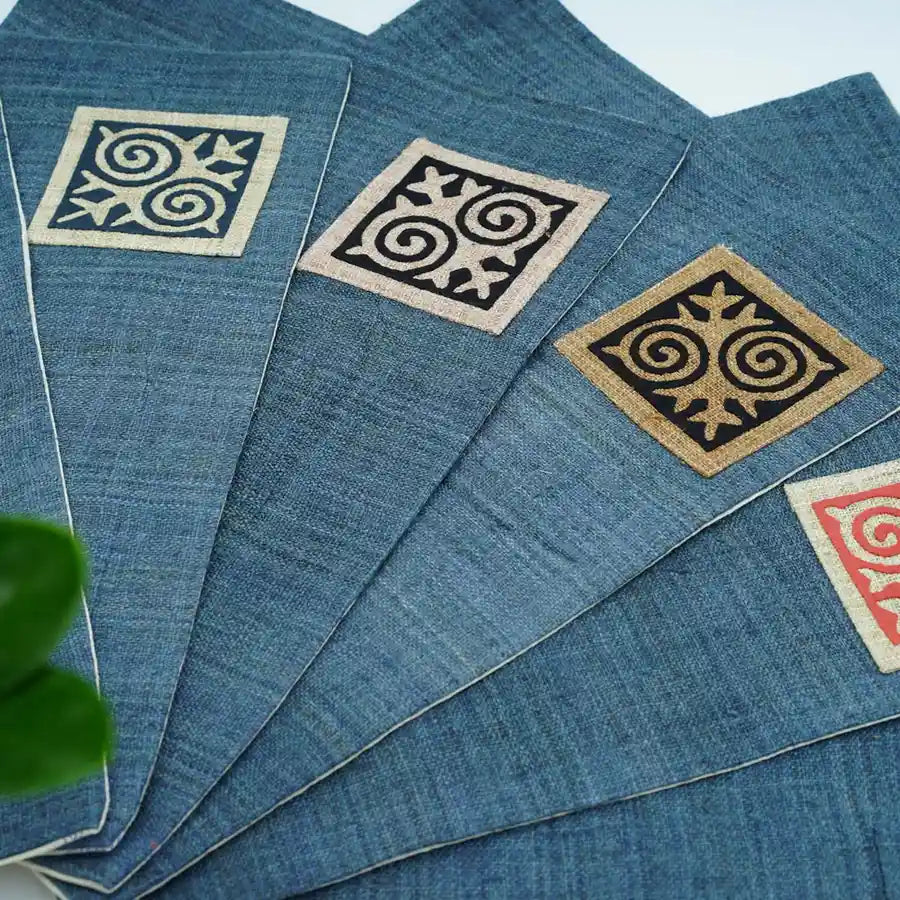 Blå bomullsservetter med tribaltryck i vitt, svart och orange