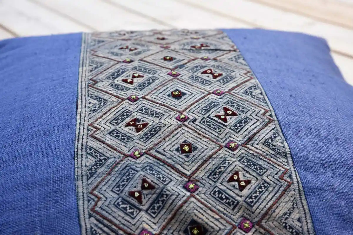 Macro view of hand-stitched tribal motif on blue cushion