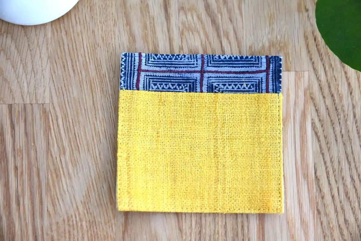 Pair of yellow hemp coasters with different indigo trims
