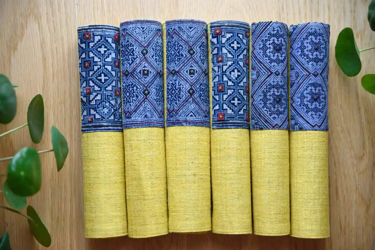 Rolled hemp napkins showing indigo tribal woven motifs on yellow base