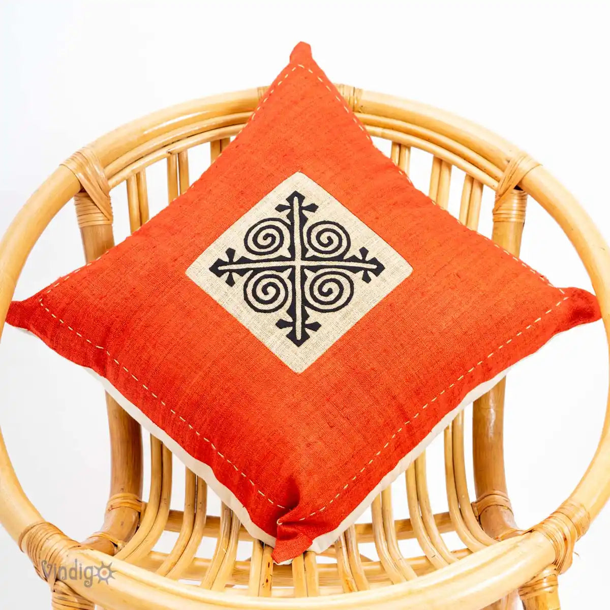 Orange kuddfodral med tribaltryck på stol i ljus inredning