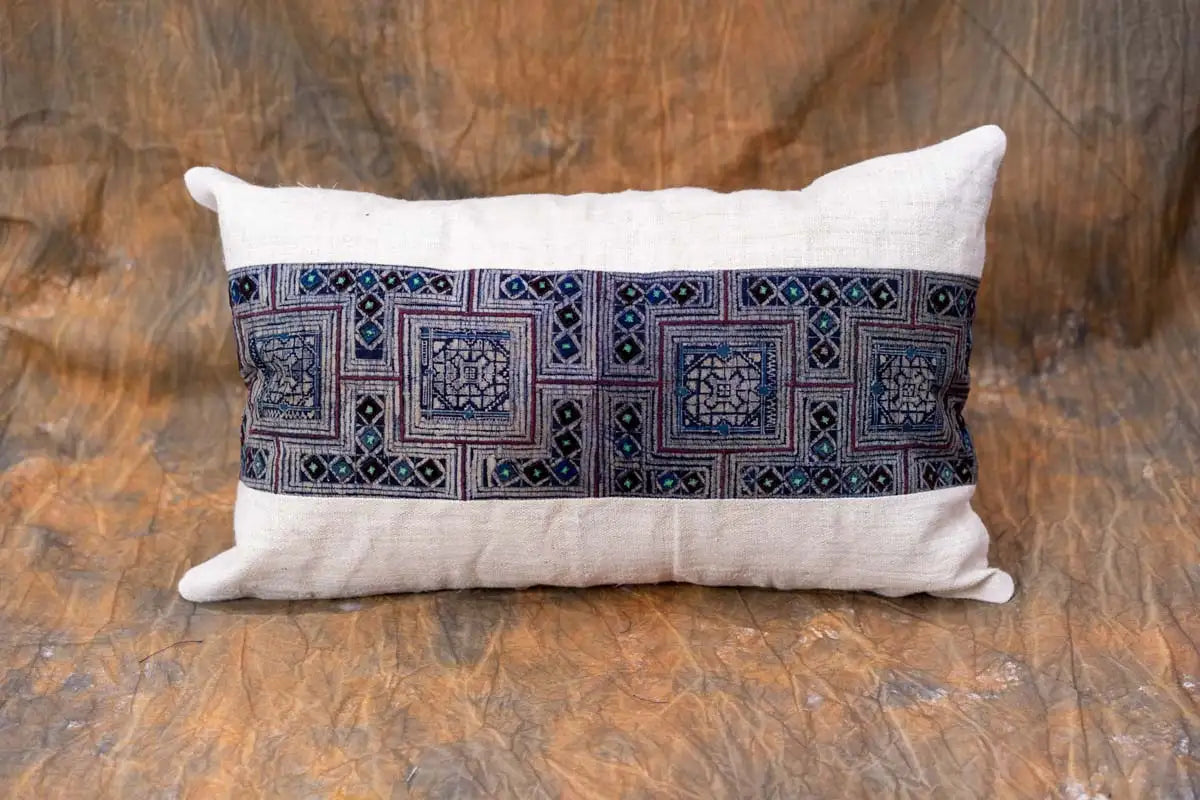 Beige hemp cushion with indigo embroidery styled on rustic background
