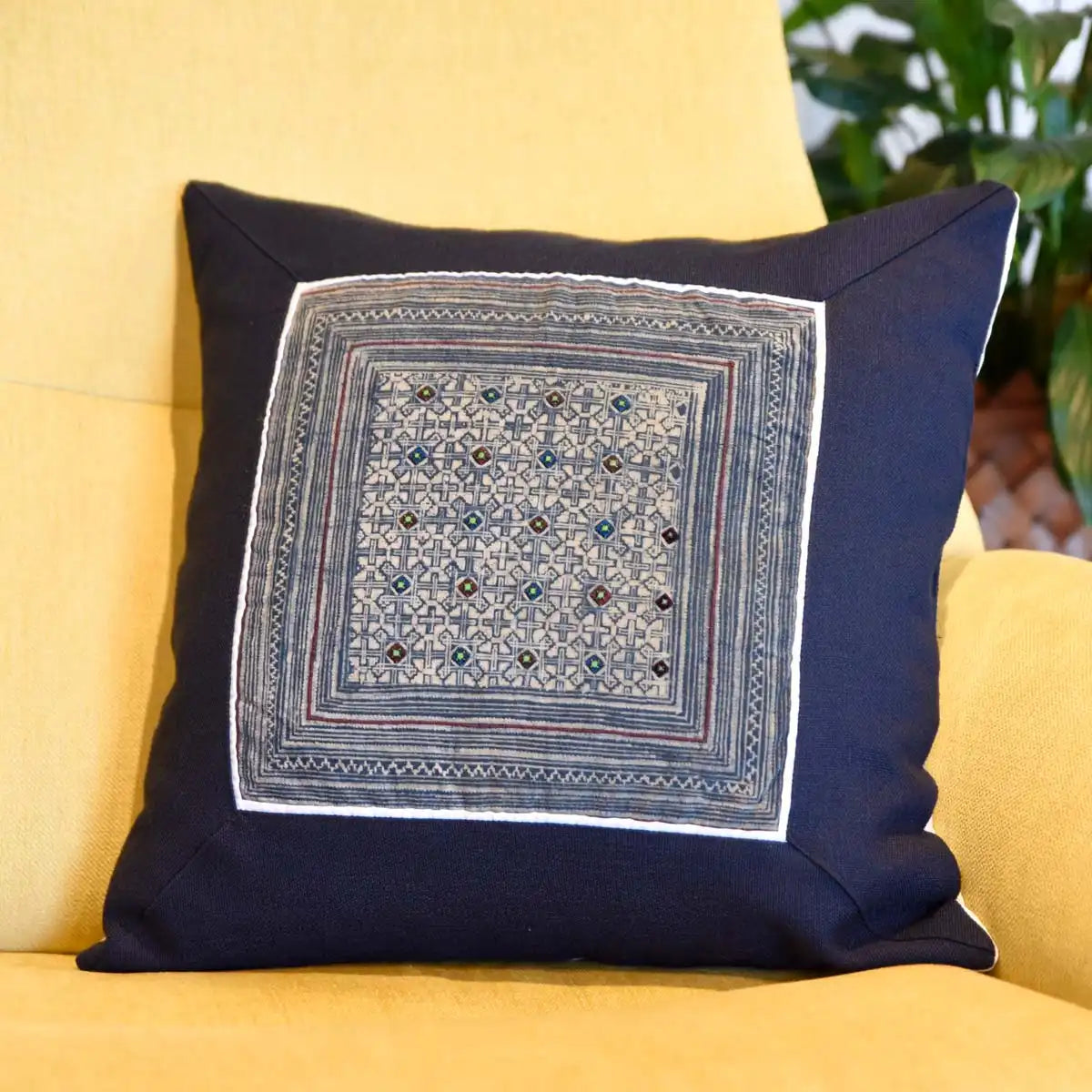 Indigo tribal cushion cover placed on yellow chair in natural light