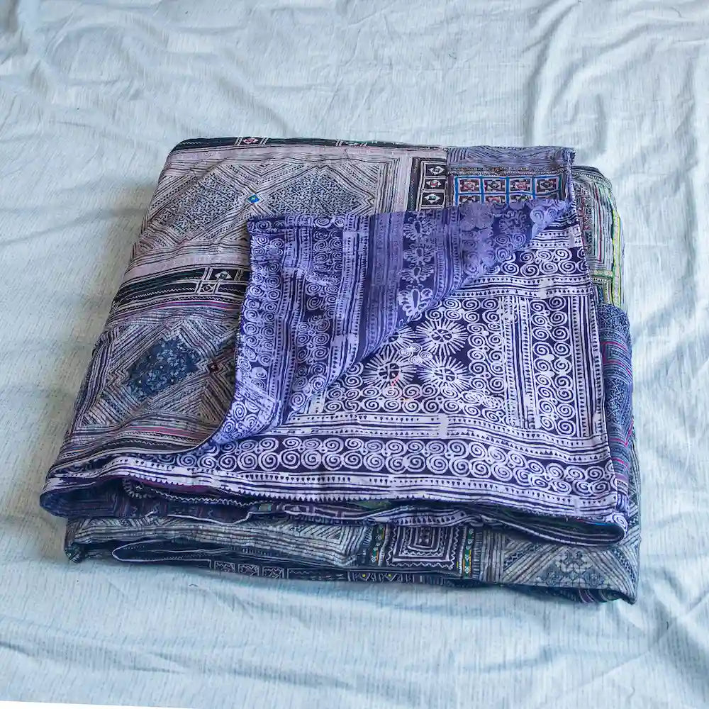 Vindigo dual-sided indigo cotton bed cover folded with batik side visible