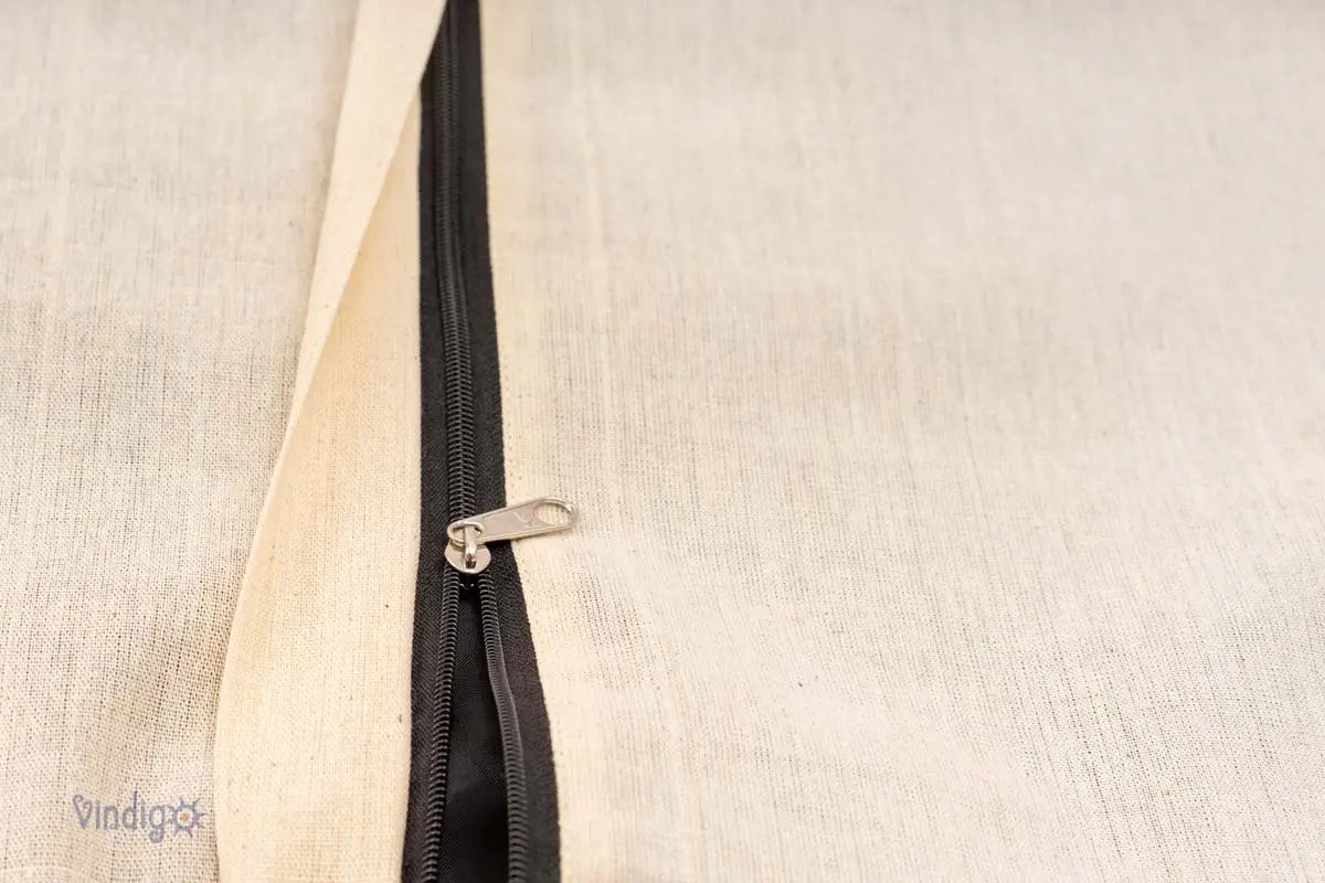 Närbild av naturfärgat kuddfodral med metallblixtlås