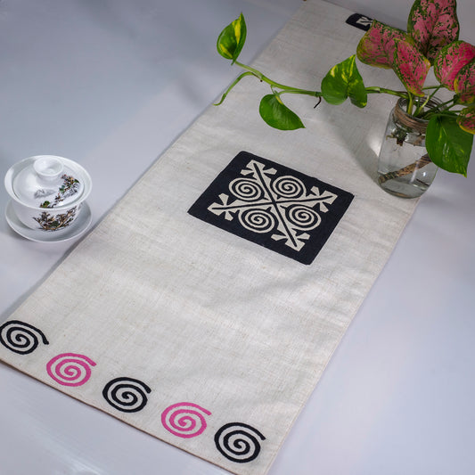 White Hemp Table Runner, white patch on black background, spiral patches in pink and black at two ends