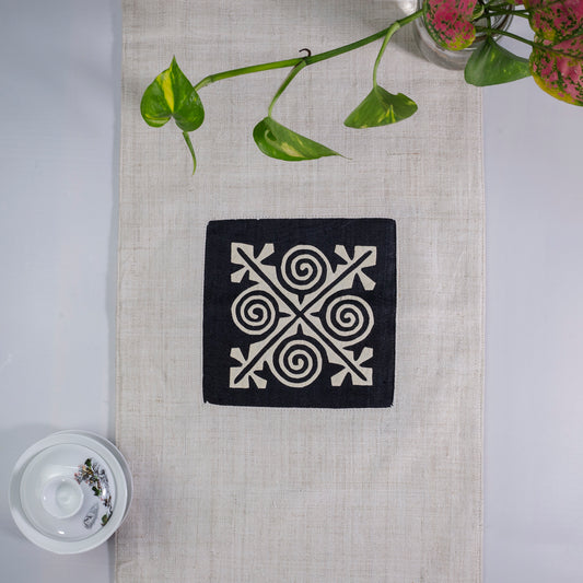 White Hemp Table Runner, white patch on black background, spiral patches in pink and black at two ends