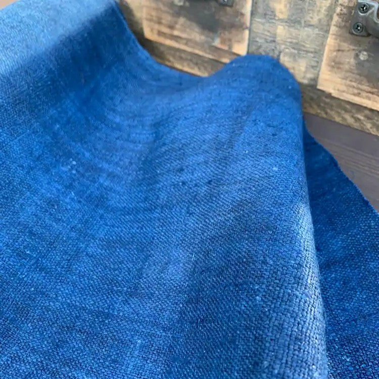 Close-up of indigo hemp fabric with a wooden surface in the background