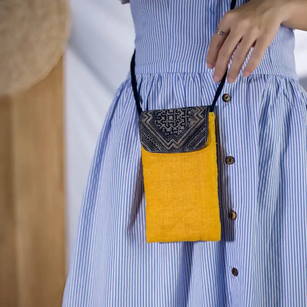 Model wearing sustainable yellow hemp phone crossbody bag with cultural vintage patch