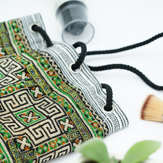 Mini hemp bag with string, tribal pattern in white on green background